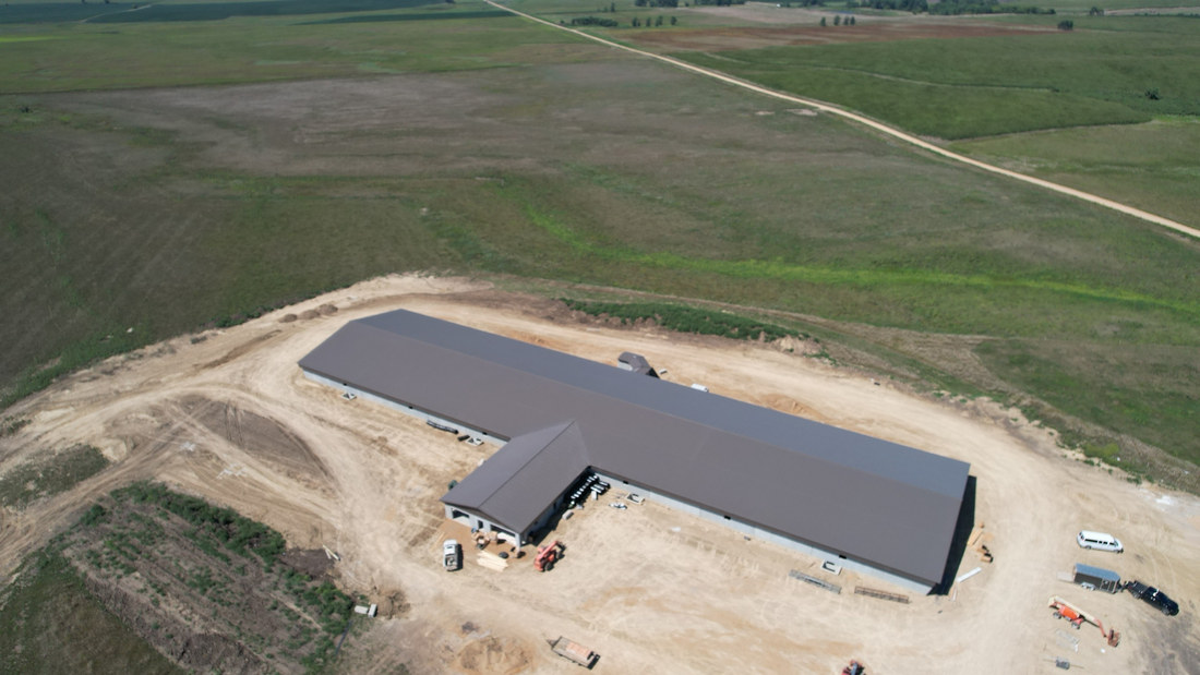 Aerial view of the finished wood frame ag building with a dark metal roof in South Dakota